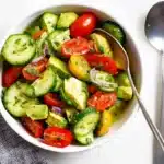 Avocado salad with cucumber and tomato in a white bowl